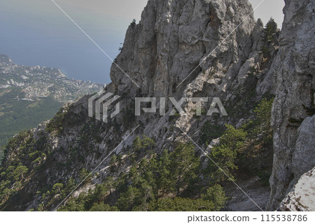 Mount Ai-petri.View from above. View from the mountain, below is a valley flowing into the Black Sea.You can also see many trees growing right on the rock. Mount Ai-petri.View from above. View from the mountain, below is a valley flowing into the Black Sea.You can also see many trees growing right on the rock. 115538786