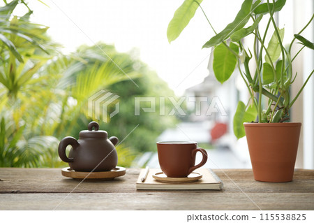 Tea cup and earthenware teapot at the balcony 115538825