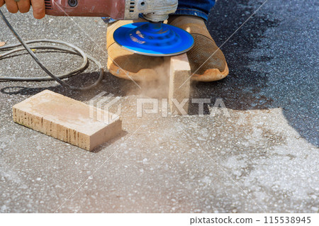 Using circular diamond disc saw, master grind the paving bricks stones before installation Using circular diamond disc saw, master grind the paving bricks stones before installation 115538945