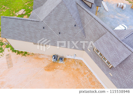 Construction roof of new house is covered with rubber asphalt roof shingles 115538946