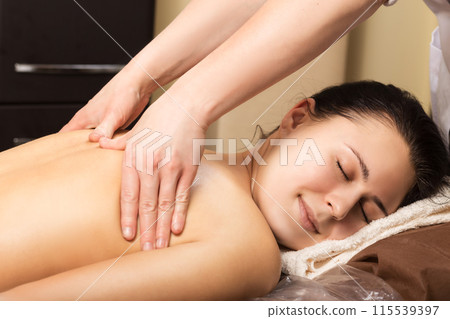 Beautiful young woman relaxing with hand massage 115539397