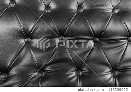 Close-up photo of the surface of the black leather seat. Black leather sofa 115539655