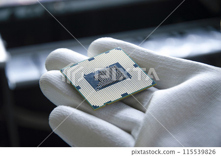 An image of a technician holding a CPU in his hand. 115539826