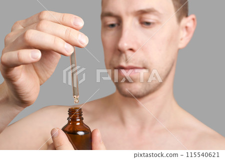 Man skin care routine. Oil pipette near male face. Hair serum product. Haircare Man skin care routine. Oil pipette near male face. Hair serum product. Haircare 115540621