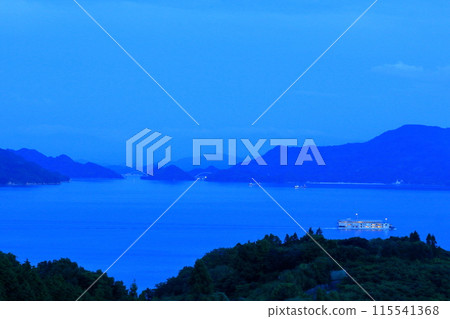 A passenger ship sailing slowly through the Seto Inland Sea at dusk 115541368