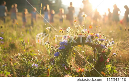 Wildflowers wreath on a sunny meadow. Sunny green natural background. Summer solstice concept. Symbol of Beltane. Wildflowers wreath on a sunny meadow. Sunny green natural background. Summer solstice concept. Symbol of Beltane. 115543458