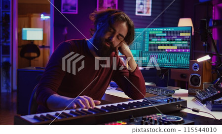 Songwriter getting upset after hearing wrong piano notes, trying to compose a song using midi controller electronic keyboard. Musician playing instrument keys to create the perfect sound. Camera B. 115544010