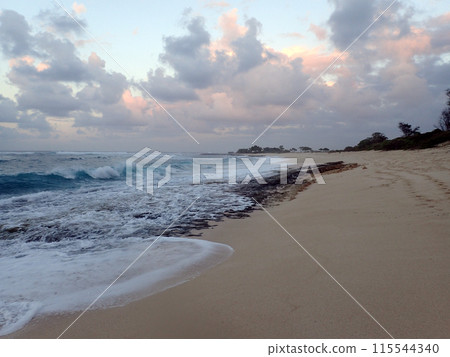 Waves break and crash towards the Hanakailio Beach with dramatic blue-pink cloudy skyline at dusk Waves break and crash towards the Hanakailio Beach with dramatic blue-pink cloudy skyline at dusk 115544340