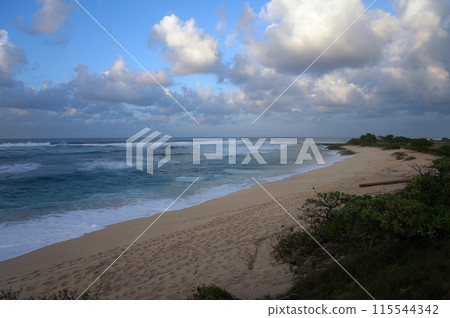 Waves break and crash towards the Hanakailio Beach with dramatic blue-pink cloudy skyline at dusk Waves break and crash towards the Hanakailio Beach with dramatic blue-pink cloudy skyline at dusk 115544342