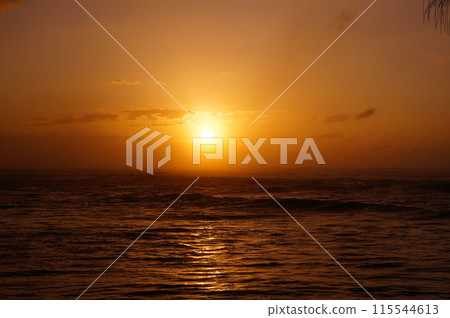 Sunset over the ocean with waves moving to shore Sunset over the ocean with waves moving to shore 115544613