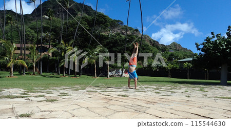 Man Handstanding stone foundation in park 115544630