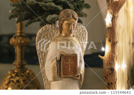Angel with wings holds a bible Scene of the birth of Jesus Christ 115544643