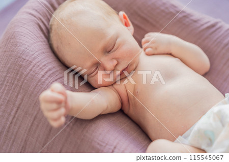 The baby is sleeping peacefully in his cozy nest. Newborn photo session captures the serene innocence and warmth of early moments 115545067