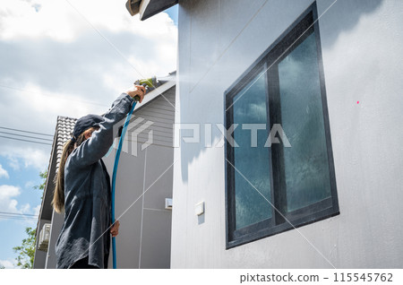 Female engineer using hose for testing window leak by spray water. Female engineer using hose for testing window leak by spray water. 115545762