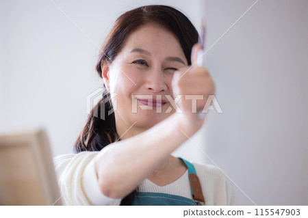 Hobby: Senior woman drawing 115547903