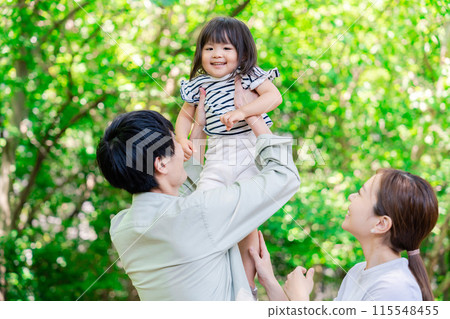 A family holding a child in the greenery 115548455
