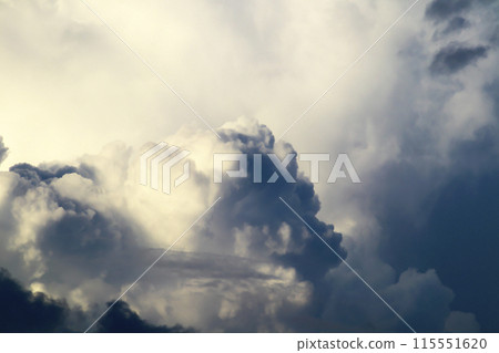 A cumulonimbus cloud has appeared in the blue sky and is growing large and ominously. 115551620