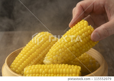 將玉米放入蒸籠蒸熟，手握蒸籠 115552079