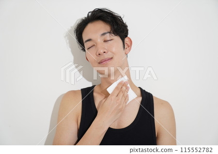 A young man wiping sweat with a sweat wipe A young man wiping sweat with a sweat wipe 115552782