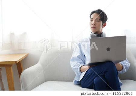 Young man relaxing in the living room Young man relaxing in the living room 115552905