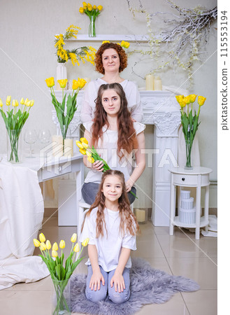 Happy Mother's Day. Daughters congratulate their mother on Women's Day on March 8. Family holiday and togetherness. 115553194