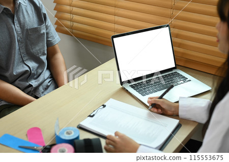 Physical therapist talking to male patient about treatment in clinic. Health care and recovery concept Physical therapist talking to male patient about treatment in clinic. Health care and recovery concept 115553675