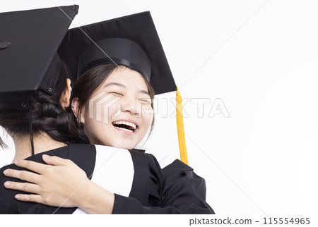 Happy high school girl friend graduates hugging in cap and gown Happy high school girl friend graduates hugging in cap and gown 115554965