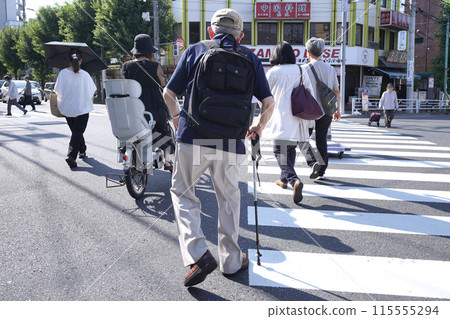 日本橫濱城市景觀:老化社會。拄著拐杖的男子穿過行人穿越道…身體向右傾斜…=橫濱市 日本橫濱城市景觀:老化社會。拄著拐杖的男子穿過行人穿越道…身體向右傾斜…=橫濱市 115555294
