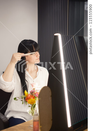 Young woman at hair salon taking care of her look 115555900