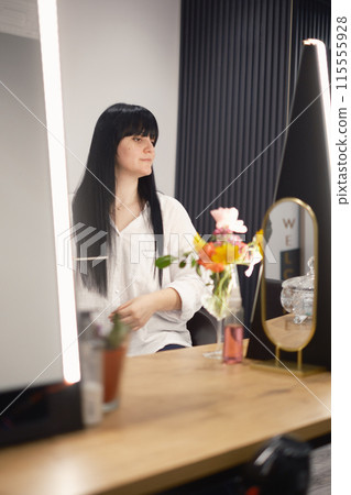 Young woman at hair salon taking care of her look Young woman at hair salon taking care of her look 115555928