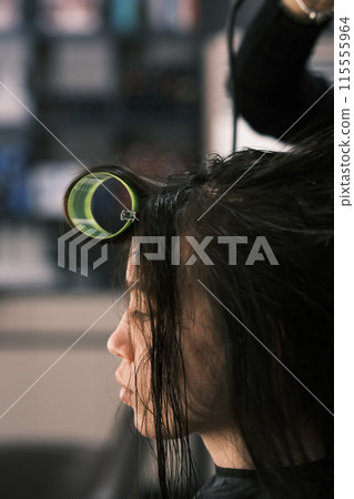 Hair stylist working in a salon. Blurred image for background 115555964