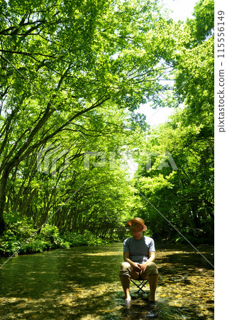 Senior man enjoying the coolness of a mountain stream in summer Senior man enjoying the coolness of a mountain stream in summer 115556149