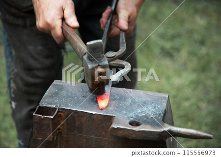 Close up view of heated metal and anvil. Close up view of heated metal and anvil. 115556973