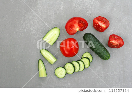 Image of fresh cucumbers and tomatoes on a light gray background. 115557524
