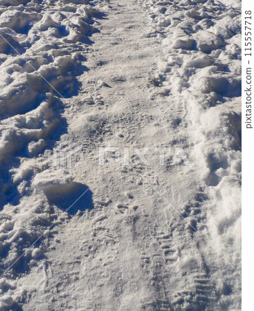 The path in the snow with human footprints. 115557718