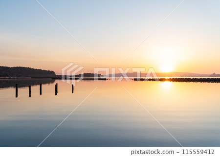 The sun rising over the disaster area and the mirror-like waters of Nanao Nishi Bay 115559412