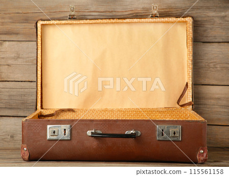 Open old leather portable suitcase for travel trip on grey background with copy space 115561158