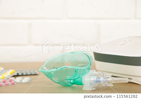 Compressor nebulizer with mask and pills on table. Top view 115561202
