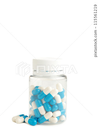 Blue pills in a bottle isolated on white background 115561219