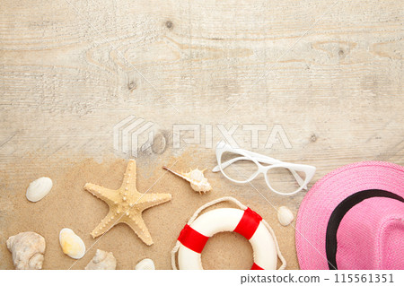Beach hat with seashells and sand on light background Beach hat with seashells and sand on light background 115561351