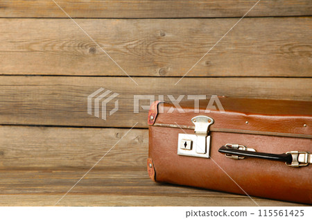 Old shabby leather portable suitcase for travel trip on grey background with copy space 115561425