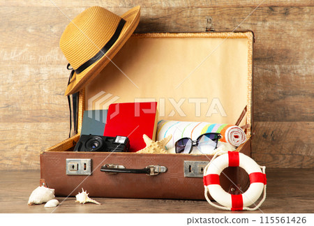 Vintage suitcase and beach accessories on brown background 115561426