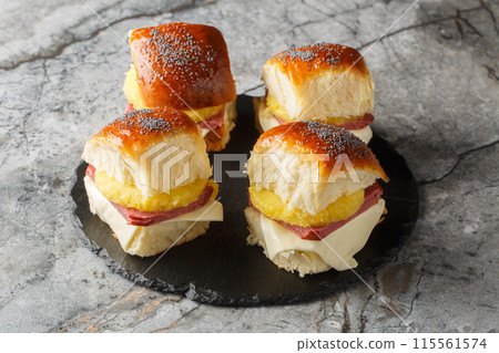 Hawaiian Ham, pineapple and Cheese Buns with butter and Poppy Seeds closeup on the slate board. Horizontal Hawaiian Ham, pineapple and Cheese Buns with butter and Poppy Seeds closeup on the slate board. Horizontal 115561574