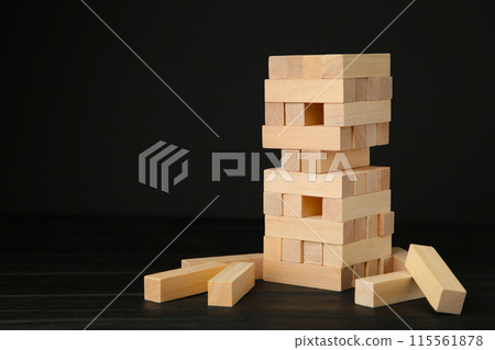 Blocks of wood on black background. Tower 115561878
