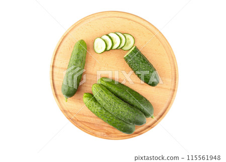 Fresh cucumbers on a wooden cutting board isolated on white background Fresh cucumbers on a wooden cutting board isolated on white background 115561948