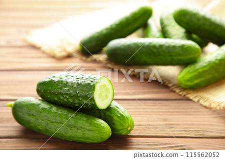Fresh cucumber slices on brown wooden background. Fresh cucumber slices on brown wooden background. 115562052