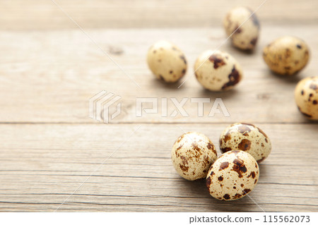 Many quail eggs on a grey background 115562073