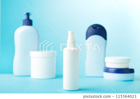 Different cosmetic bottles on blue background. Top view 115564021