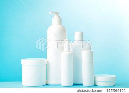 White cosmetic bottles on blue background. Top view 115564121