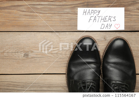 Happy Fathers Day message and black shoes on grey wooden background. Happy Fathers Day message and black shoes on grey wooden background. 115564167